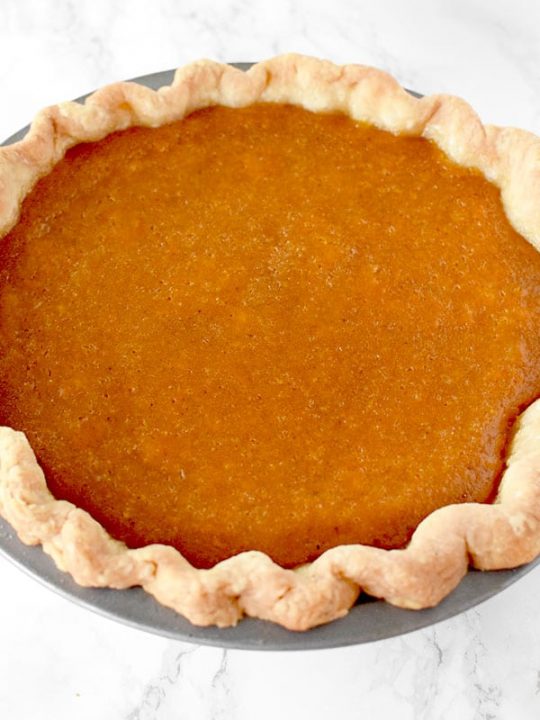 Dairy Free sweet potato pie in a homemade pie crust on a marble counter