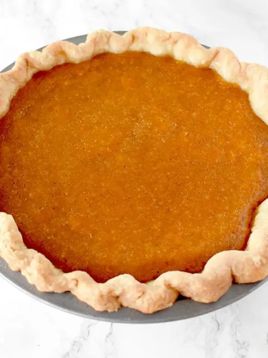 Dairy Free sweet potato pie in a homemade pie crust on a marble counter