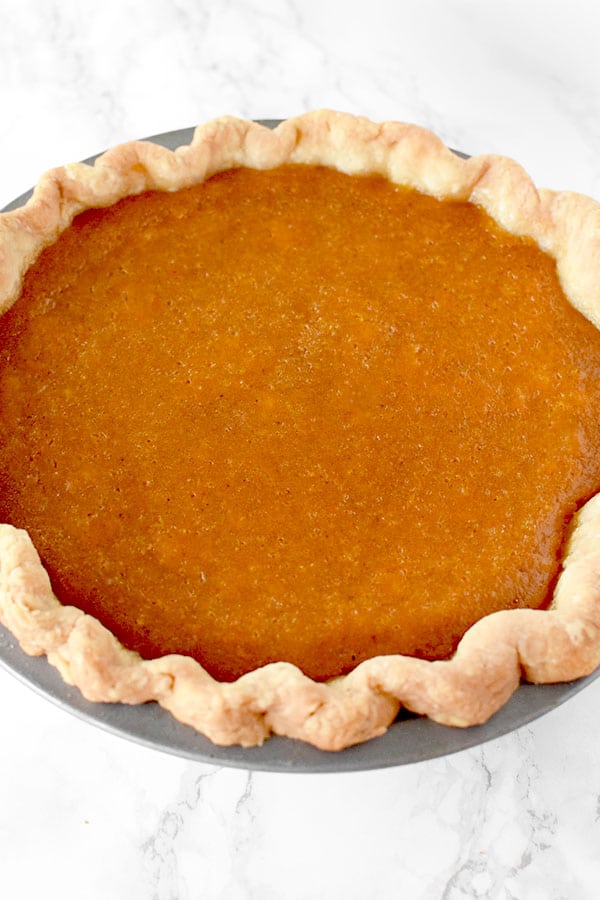 Dairy Free sweet potato pie in a homemade pie crust on a marble counter