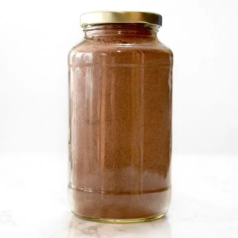 jar filled with dairy free chocolate cake mix on a marble counter