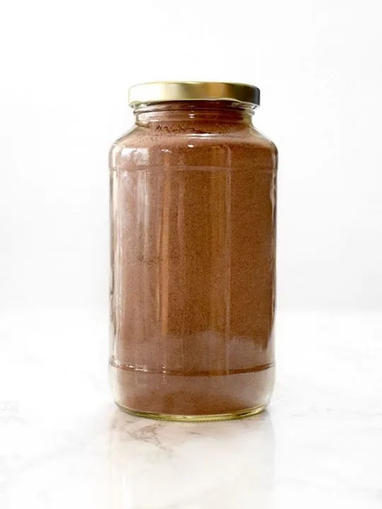 jar filled with dairy free chocolate cake mix on a marble counter