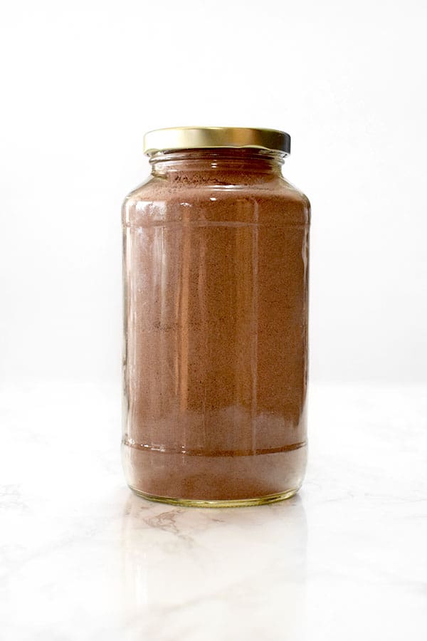 jar filled with dairy free chocolate cake mix on a marble counter