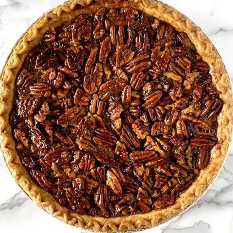 Dairy free pecan pie sitting on a white marble counter