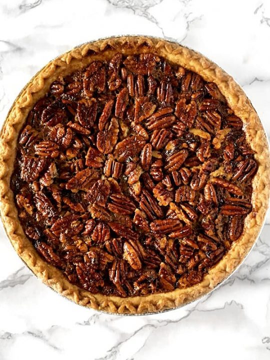 Dairy free pecan pie sitting on a white marble counter