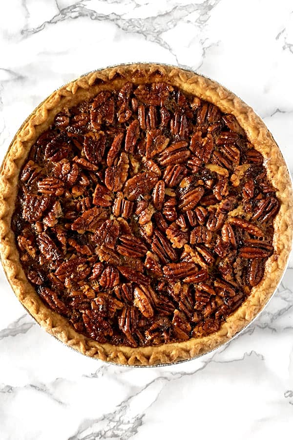 Dairy free pecan pie sitting on a white marble counter