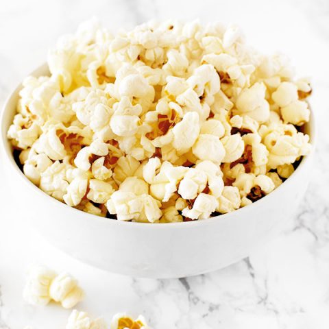 Kettle corn in a white bowl on a white marble counter