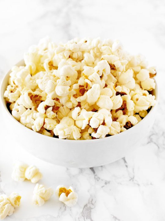 Kettle corn in a white bowl on a white marble counter