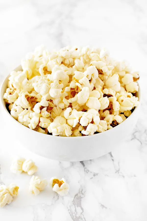 Kettle corn in a white bowl on a white marble counter