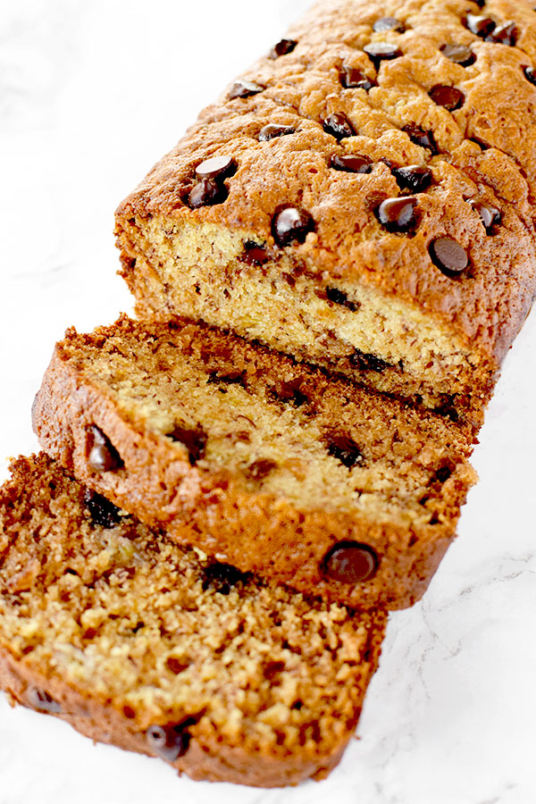 sliced banana chocolate chip bread on a white marble counter