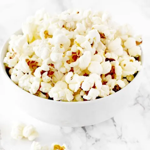 popcorn in a white bowl on a white marble counter