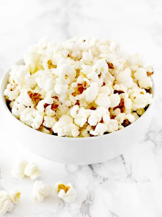 popcorn in a white bowl on a white marble counter