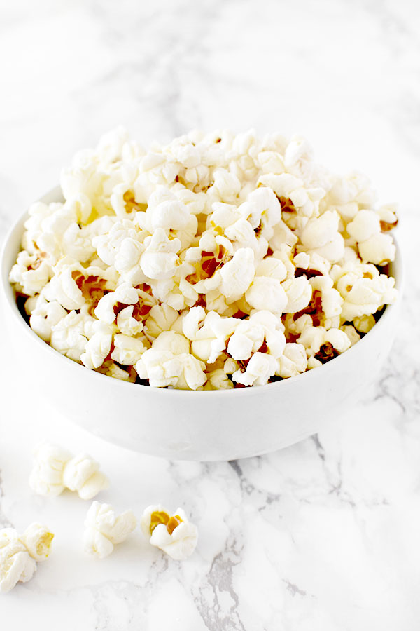 popcorn in a white bowl on a white marble counter