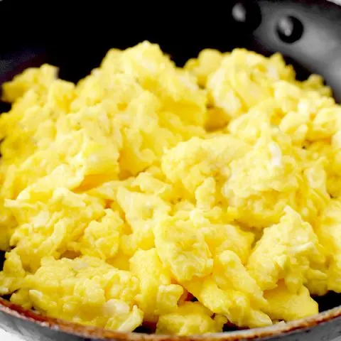 scrambled eggs in a frying pan on a marble counter