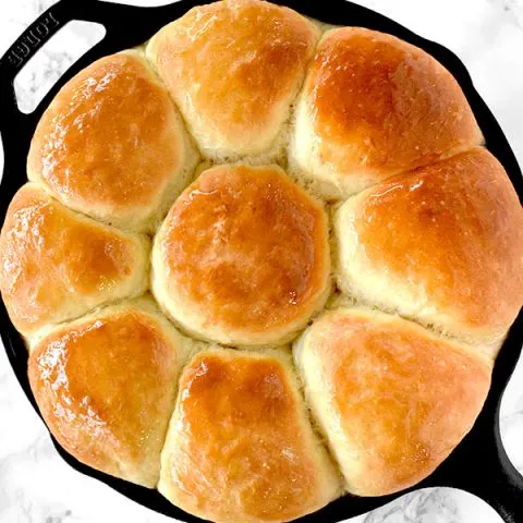 Dairy free dinner rolls in a cast iron skillet on a white marble counter