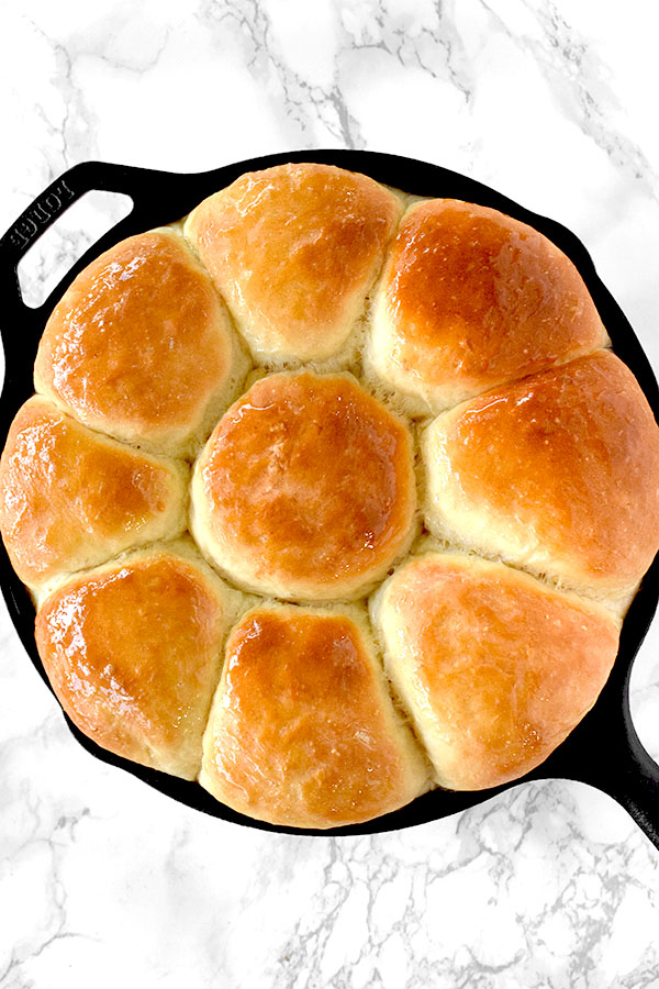 Dairy free yeast rolls in a cast iron skillet on a white marble counter