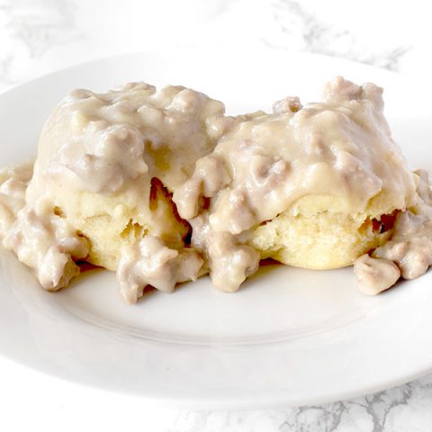 Dairy Free biscuits and gravy on a white plate on a white marble counter