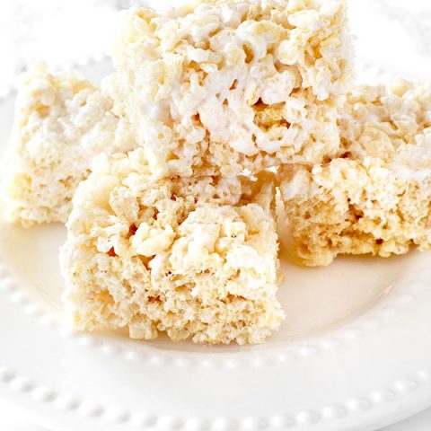 Dairy Free Rice Krispie Treats stacked on a white plate on a white marble counter