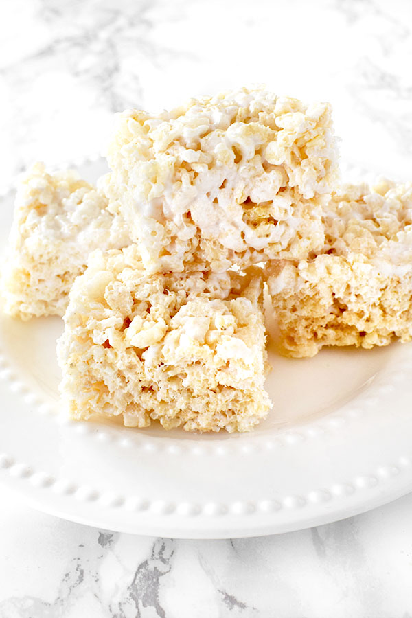 Dairy Free Rice Krispie Treats stacked on a white plate on a white marble counter