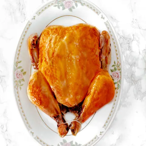 dairy free roasted turkey on platter on a white marble counter