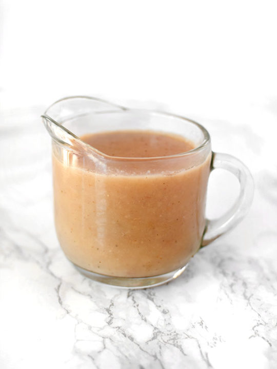 Dairy free gravy in a glass gravy boat on a white marble counter