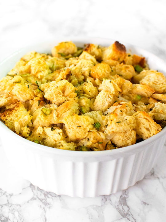 Dairy free stuffing or dressing in a white casserole dish on a white marble counter