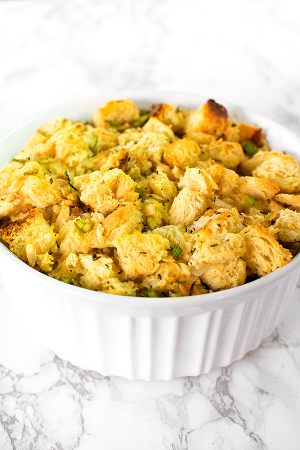 Dairy free stuffing or dressing in a white casserole dish on a white marble counter