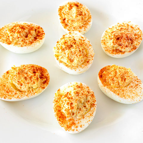 deviled eggs on a white plate on a white marble counter