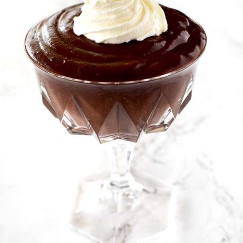 chocolate pudding in a glass up on a white marble counter