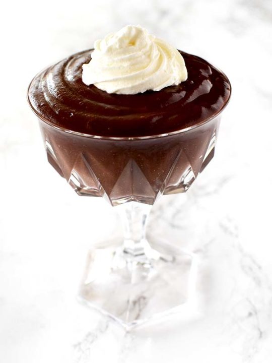 chocolate pudding in a glass up on a white marble counter