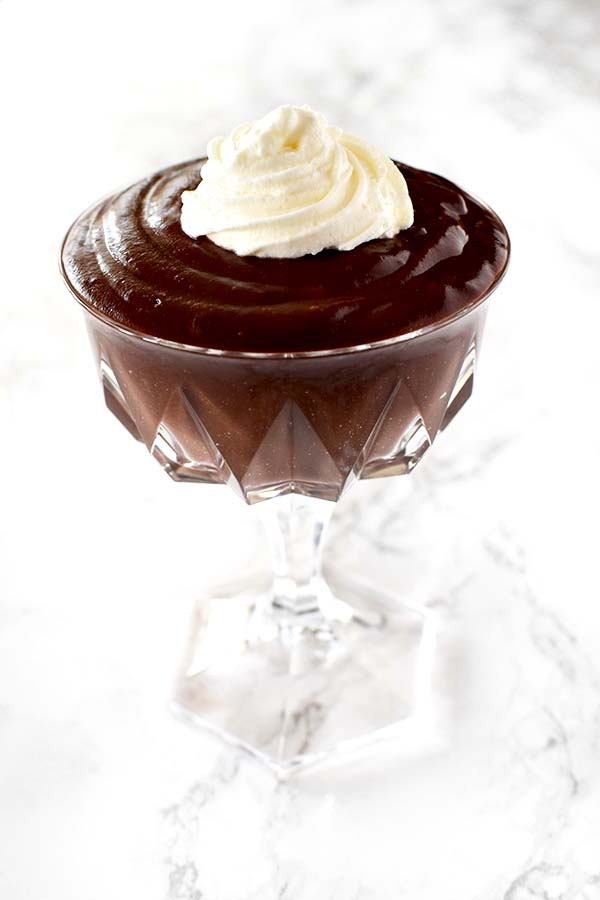 chocolate pudding in a glass up on a white marble counter