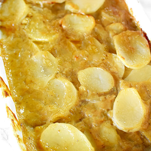 dairy free scalloped potatoes in a white casserole dish on a white marble counter