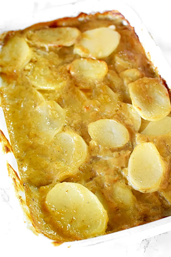 dairy free scalloped potatoes in a white casserole dish on a white marble counter