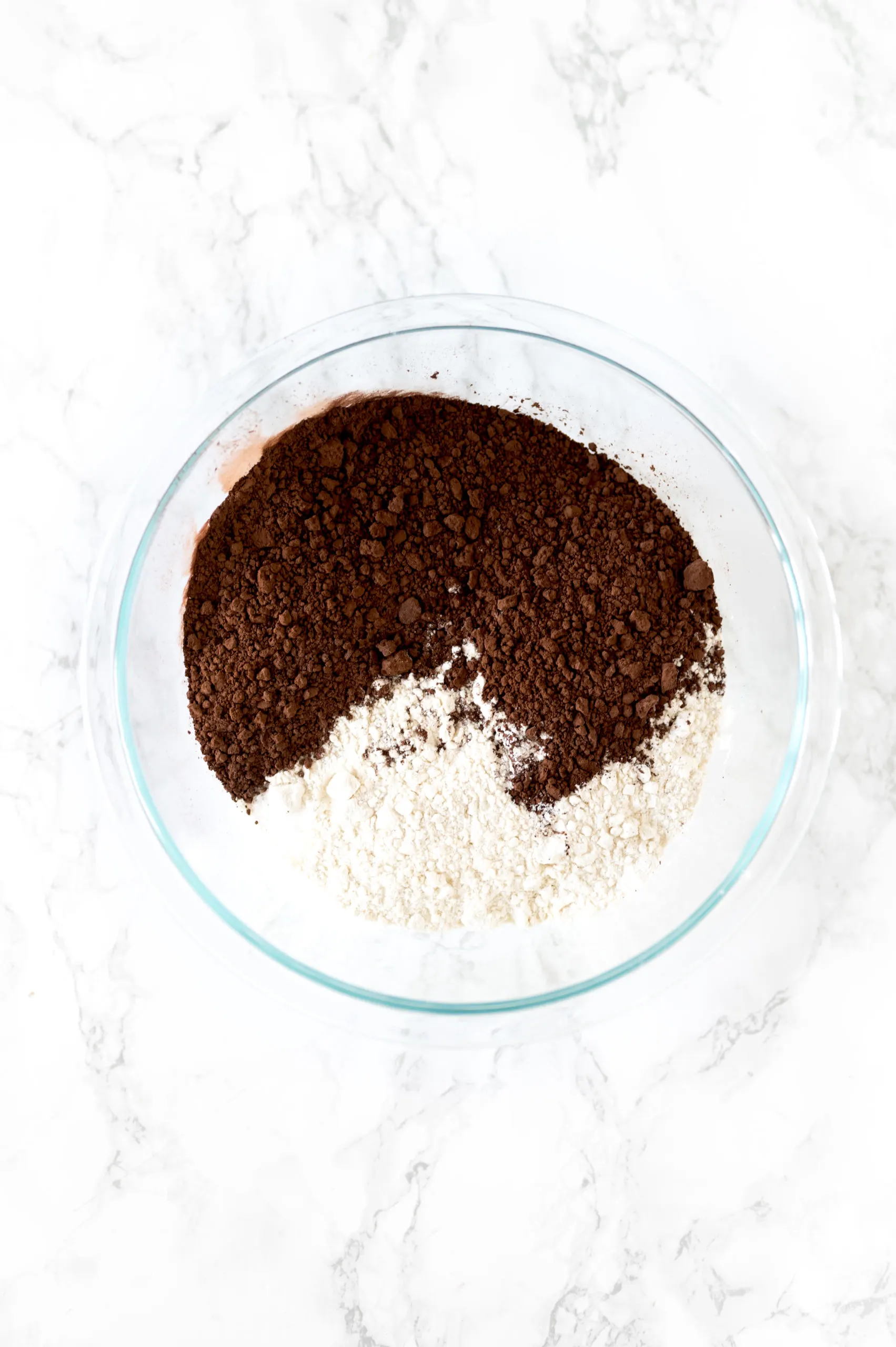 dry ingredients chewy brownie in a bowl on a white marble counter