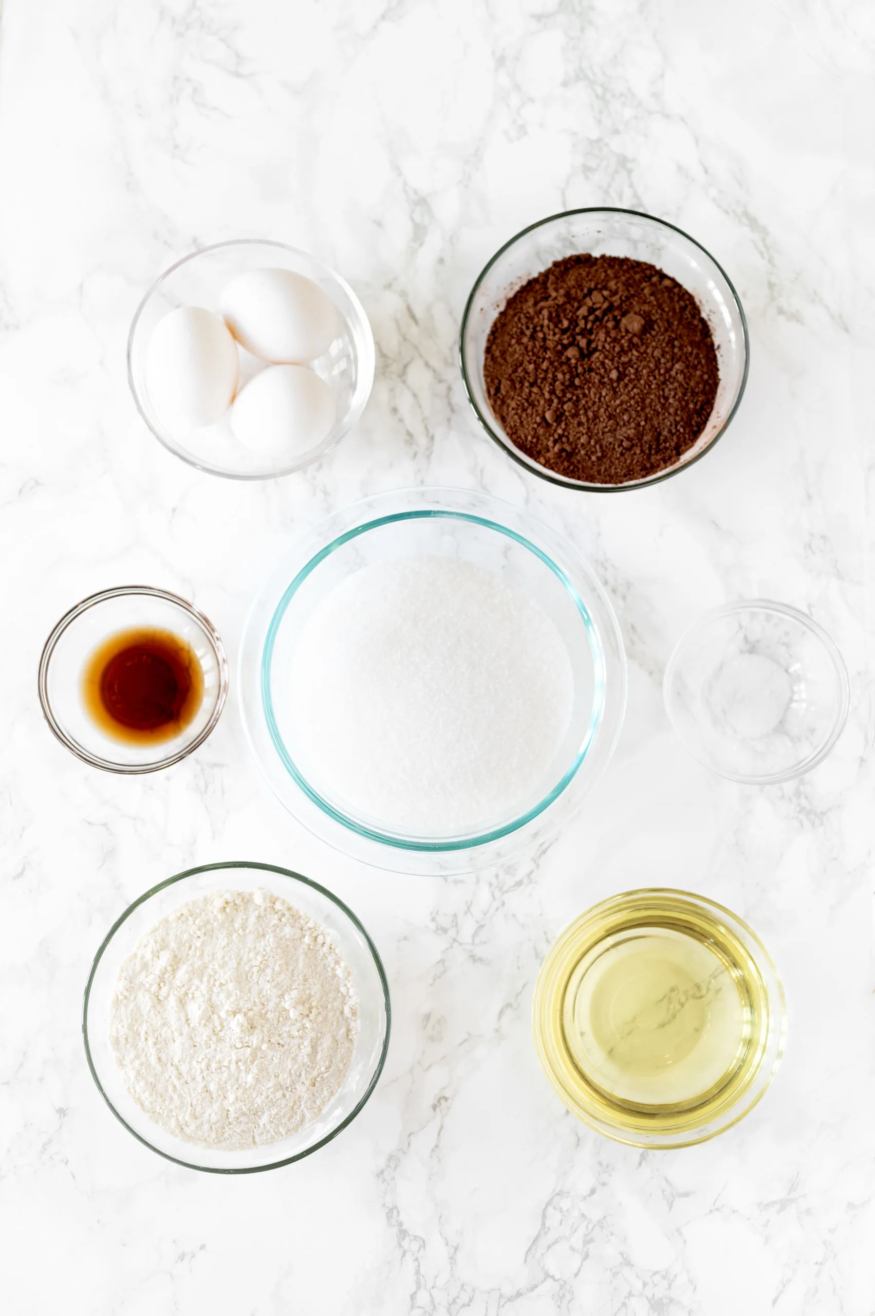 chewy brownie ingredients in little bowls on a white marble counter