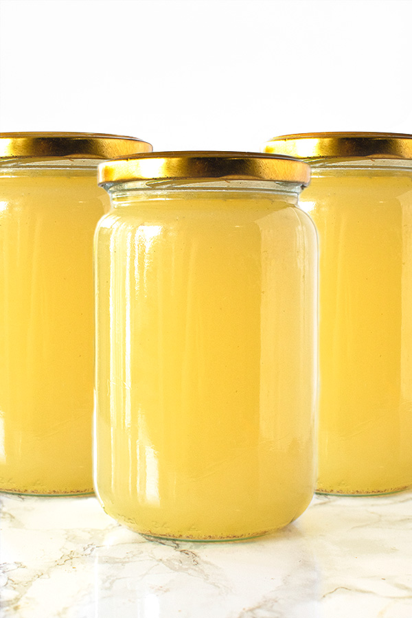 Chicken Wing Stock in jars on a white marble counter