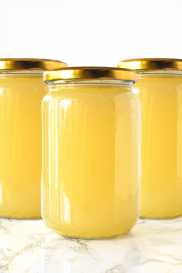 Chicken Wing Broth in jars on a white marble counter