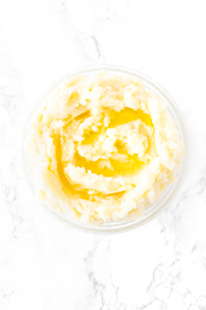 mashed potatoes in a bowl on a white marble counter