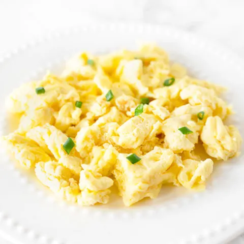 scrambled eggs with mayonnaise on a white plate on a white marble counter
