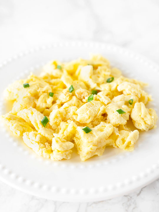 scrambled eggs with mayonnaise on a white plate on a white marble counter