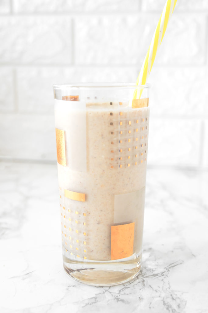 Banana Smoothie without Milk in a glass on a white counter with a yellow straw