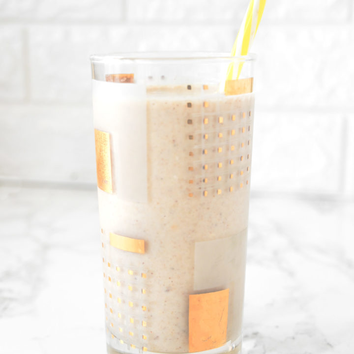 Banana Smoothie without Milk in a glass on a white counter with a yellow straw