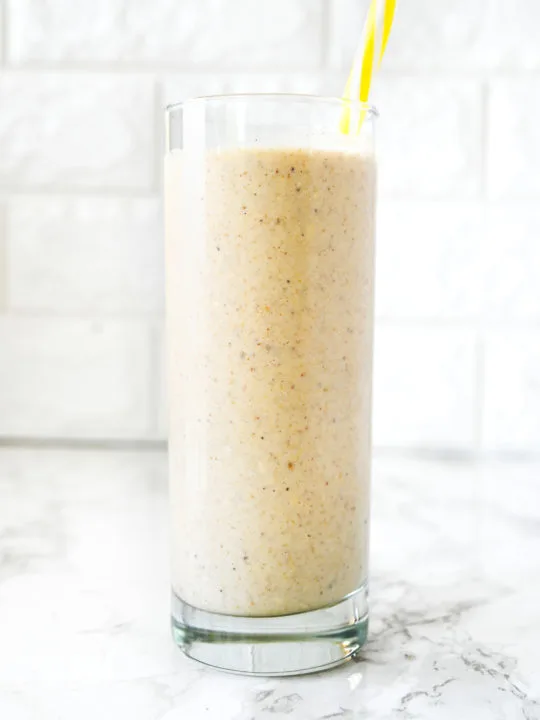 Dairy Free Banana Smoothie on a white counter with a yellow straw