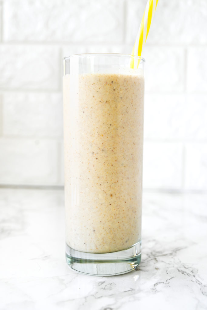 Dairy Free Banana Smoothie on a white counter with a yellow straw