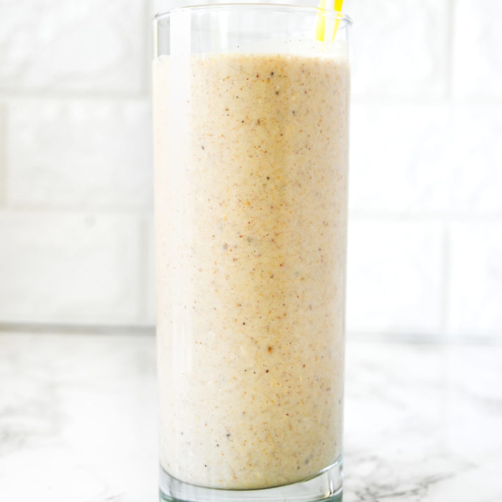 Dairy Free Banana Smoothie on a white counter with a yellow straw