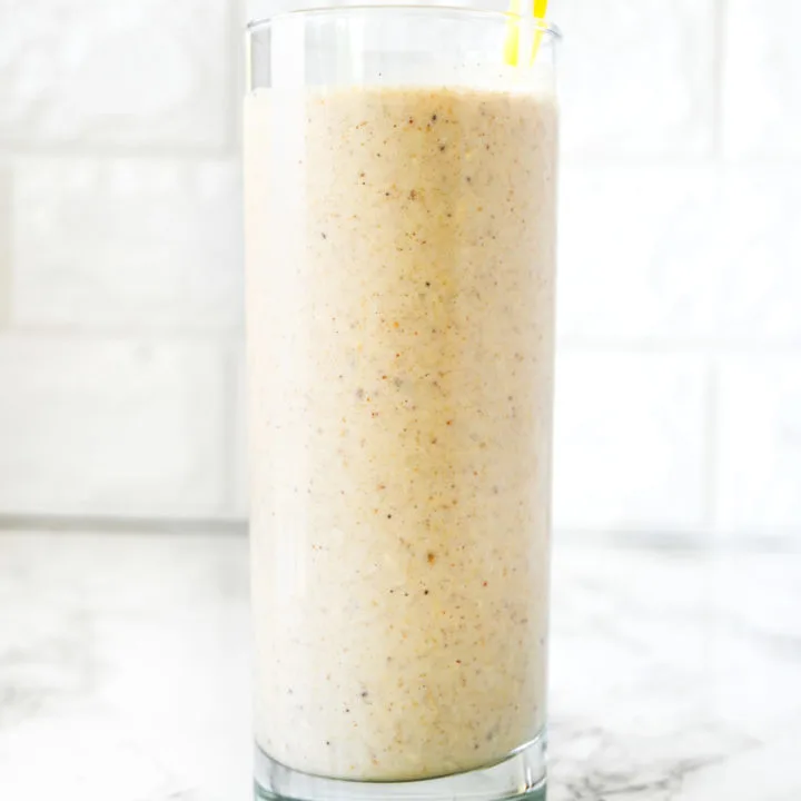 Dairy Free Banana Smoothie on a white counter with a yellow straw