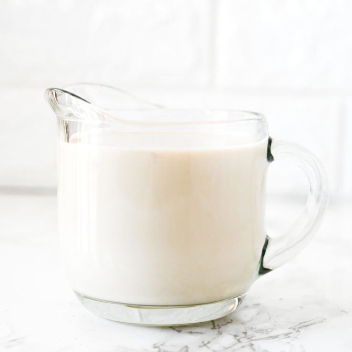 dairy free buttermilk in a glass creamer on a white marble counter