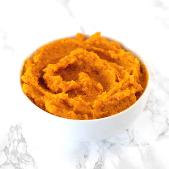 Mashed Sweet Potatoes in a white bowl on a white counter