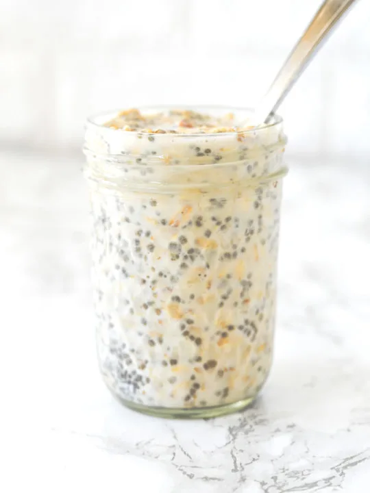Overnight Oats in a jar with a spoon on a white marble counter
