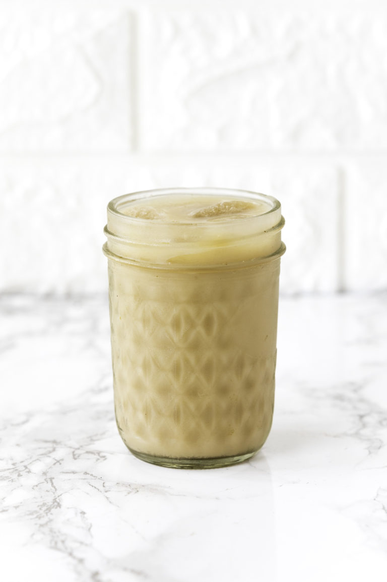Iced coffee in a mason jar on white counter