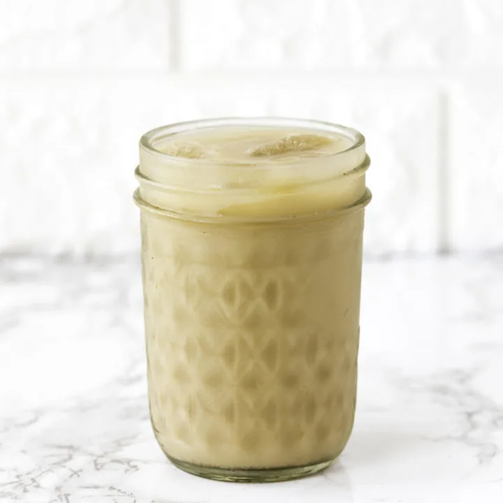 Iced coffee in a mason jar on white counter